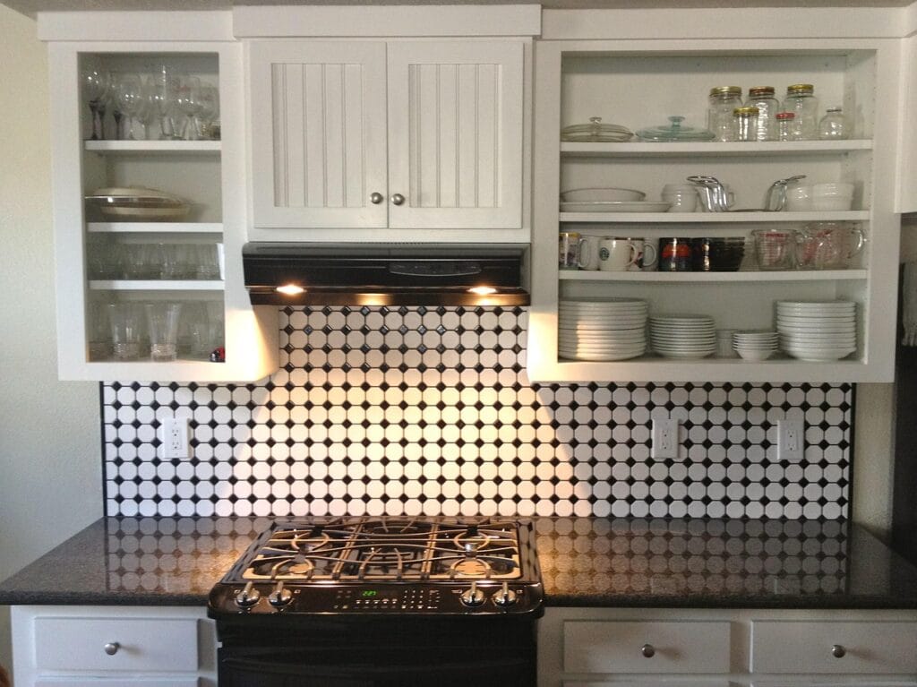 Wiping grease off a kitchen cabinet next to the stove with a microfiber cloth